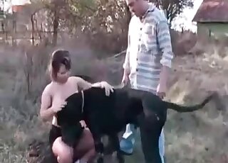 Good-looking chubby babe teasing a black dog in an outdoor vid